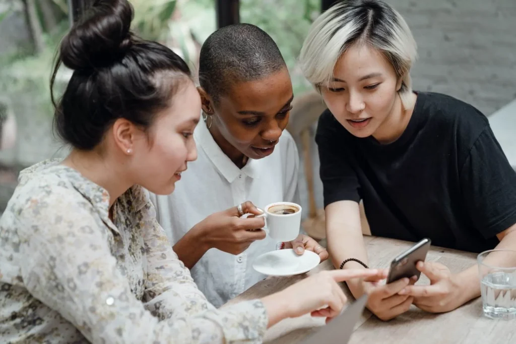 Three women looking at a phone